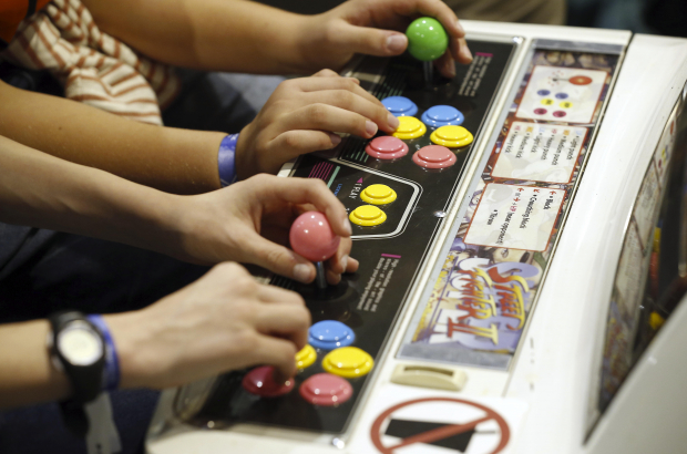 Video gamers play on an arcade console (BELGA PHOTO NICOLAS MAETERLINCK)