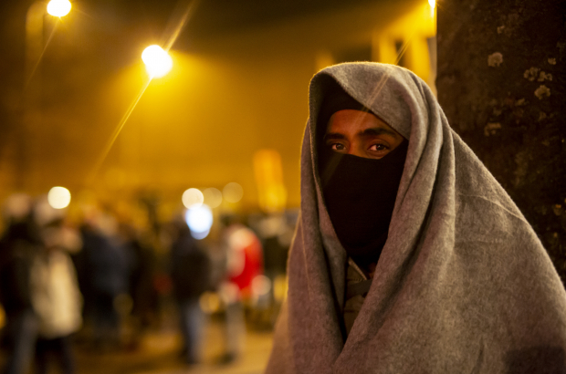 An asylum seeker takes shelter outside the immigration office in Brussels (BELGA)