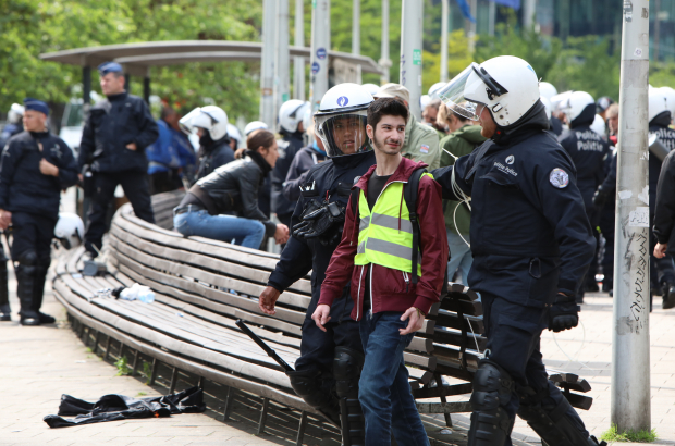 A young man is escorted away by police officers during a demonstration in Brussels (BELGA PHOTO PAUL-HENRI VERLOOY)
