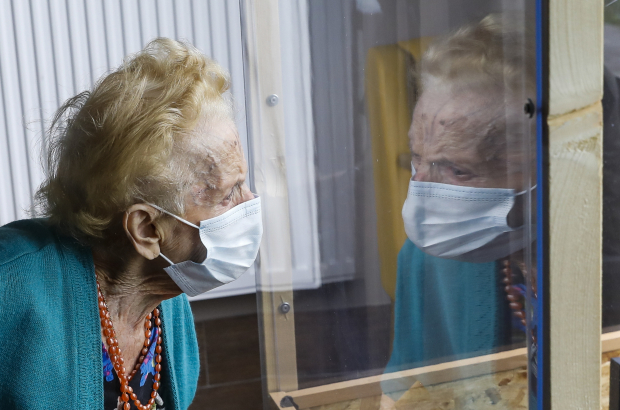 An old lady looks through a perspex screen installed at her care home in Brussels, Belgium (BELGA PHOTO)