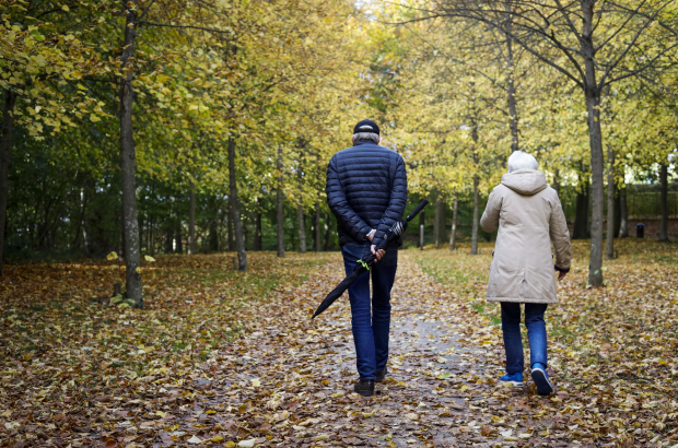 A couple walking with their dog during autumn weather at the park of Gaasbeek Castle