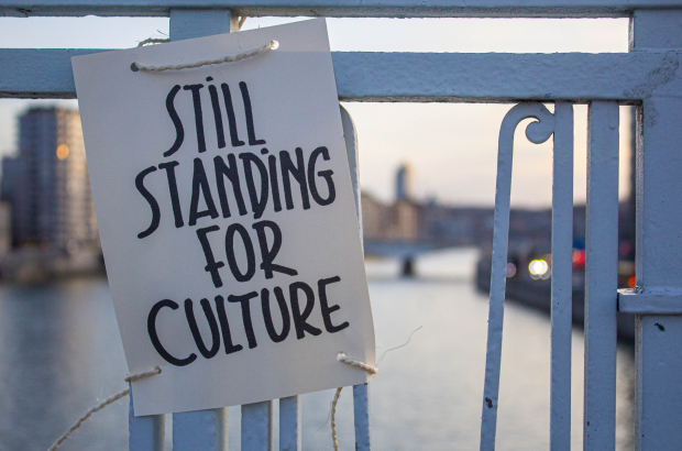 A 'Still Standing' sign shown during a protest of the cultural sector, in Liege, Saturday 20 February 2021. The cultural and creative sectors are struggling as events have been cancelled because of the pandemic. (BELGA PHOTO THOMAS MICHIELS)