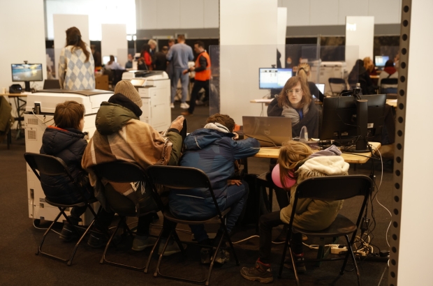 People sign in at a center for the registration of Ukrainian refugees, at the Palace 8 hall of Brussels expo, Monday 14 March 2022. The center is opened to welcome Ukrainians fleeing their country after the Russian invasion. (BELGA PHOTO JAMES ARTHUR GEKIERE)