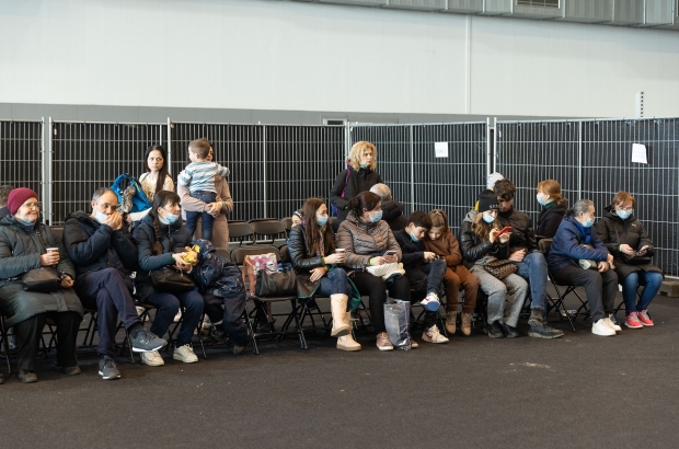 People await their turn at a centre for the registration of Ukrainian refugees, at the Palace 8 hall of Brussels expo, Monday 14 March 2022. The centre is opened to welcome Ukrainians fleeing their country after the Russian invasion. (BELGA PHOTO JAMES ARTHUR GEKIERE)