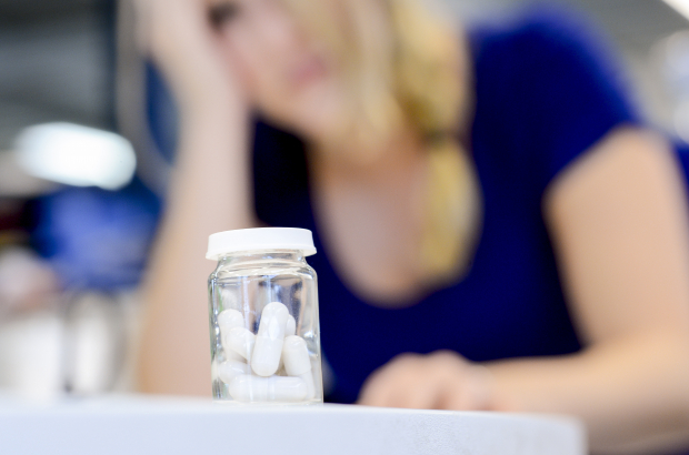 A woman looks at a bottle of antidepressants. An increase in depression, anxiety disorders and suicides have been attributed partially to the ongoing coronavirus crisis (BELGA PHOTO JONAS HAMERS)