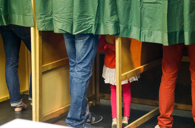 Illustration picture shows a girl in pink with her parent in the voting booth in a polling station during the federal, regional and European elections in Belgium, Sunday 25 May 2014. (BELGA PHOTO BRUNO FAHY)