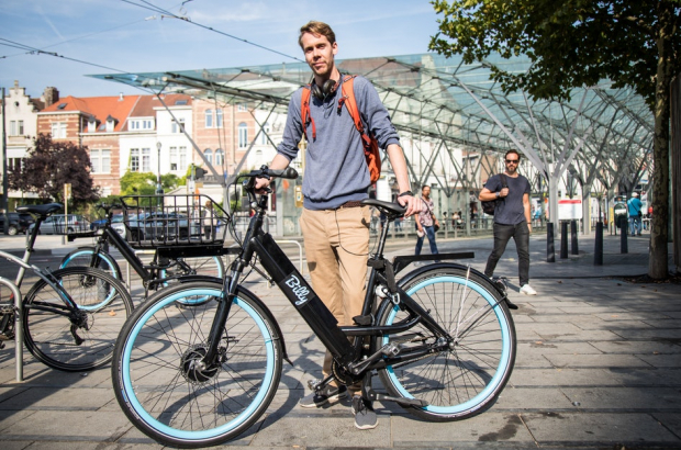 A man stands with a bicycle from bike sharing company Billy Bike in Brussels © Peter Detailleur